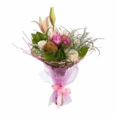 A bouquet of lilies, white roses and purple spray chrysanthemums in an original wrapping