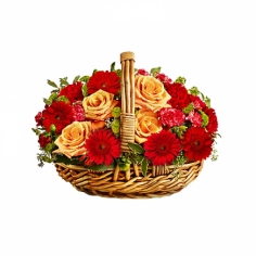 A basket with cream roses, red gerberas and carnations