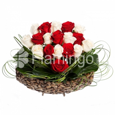A heart-shaped composition of red and white roses with green fillers in a basket