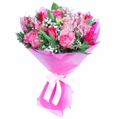 A brightly wrapped bouquet of pink roses, tulips and parrot flowers