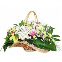 A basket with yellow chrysanthemums, pink parrot flowers and green fillers