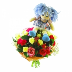 A bouquet of various roses with green fillers decorated by a doll