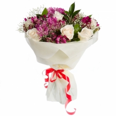 A nicely wrapped bouquet of white roses and purple chrysanthemums