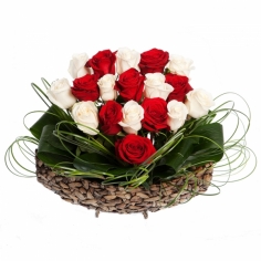 A heart-shaped composition of red and white roses with green fillers in a basket