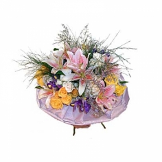 A nicely wrapped bouquet of lilies, roses and irises with green fillers