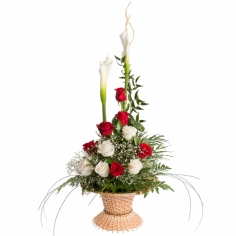 A basket arrangement with calla lilies, white and red roses and green fillers