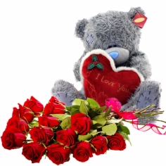A teddy bear and a bouquet of red roses