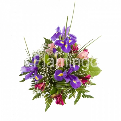 A table floral arrangement of blue irises, parrot flowers and green fillers