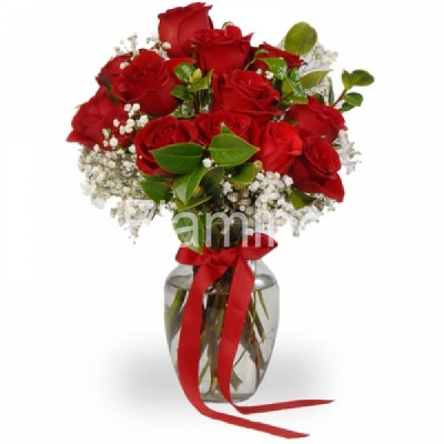 A composition of red roses with baby breath and green fillers in a vase