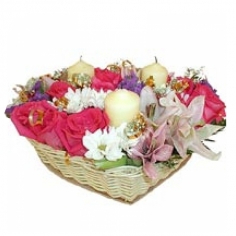 A heart-shaped basket with roses, lilies, chrysanthemums snd candles