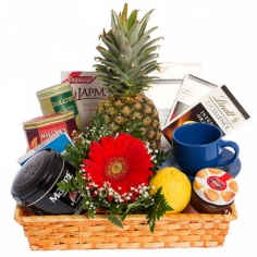 Tea, tea mug, sweets and fruit arranged in a basket