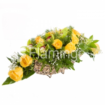 A basket with yellow roses, green orchids and green fillers