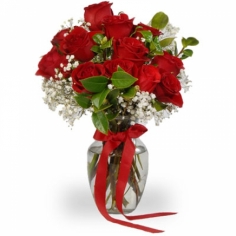 A composition of red roses with baby breath and green fillers in a vase