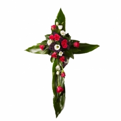 A cross-shaped funeral composition with roses and green fillers