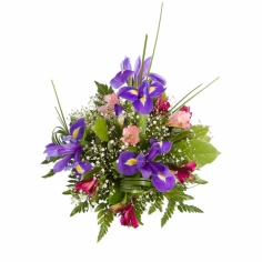 A table floral arrangement of blue irises, parrot flowers and green fillers