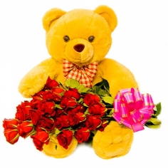 A bug teddy bear and a bouquet of red roses