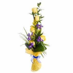 A long bouquet of yellow roses and blue irises with green fillers