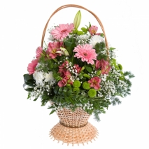A basket of various pink and white flowers with green fillers