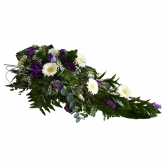 A funeral composition with gerberas, statice, eustomas and green fillers