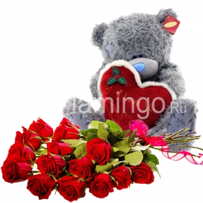 A teddy bear and a bouquet of red roses