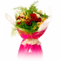 A wrapped bouquet of red roses with parrot flowers and green fillers