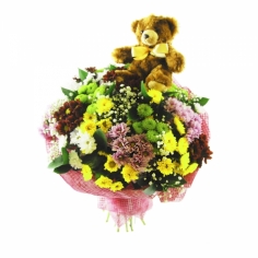 A bouquet of chrysanthemums of various colors with a small teddy bear