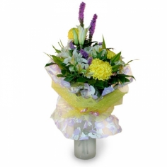 A nicely wrapped bouquet of lilies, chrysanthemums and parrot flowers in yellow colors