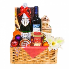 A decorated basket with caviar, wine, fruit, chocolate candies and tea