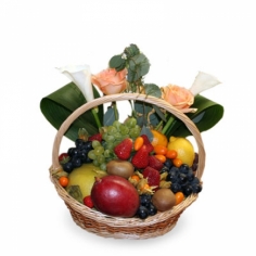 A basket with fruits, berries and red roses.