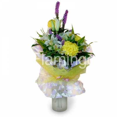 A nicely wrapped bouquet of lilies, chrysanthemums and parrot flowers in yellow colors