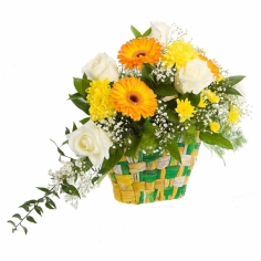 White roses, yellow gerbera daisies and chrysanthemums in a woven basket